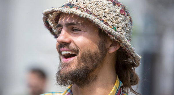 A photo of Marcus smiling to someone on the left hand side of the camera. The background is blurred.