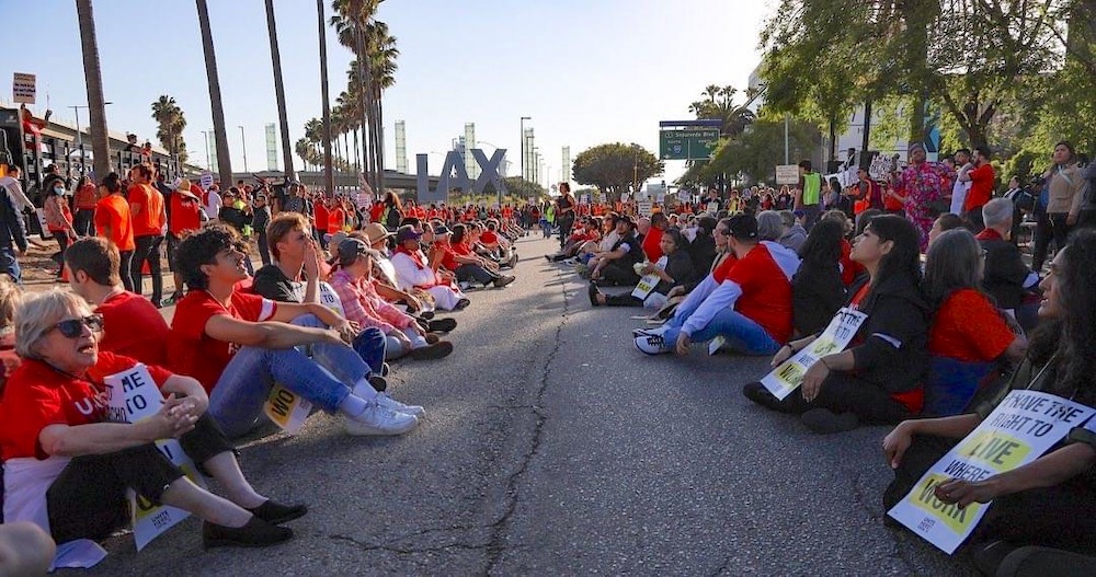 Photo of sit-in near LAX; two rows of demonstrators in red T-shirts