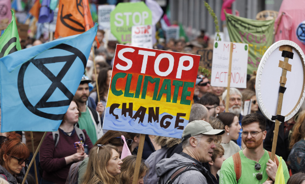 People at a protest with a placard that says “Stop climate change”