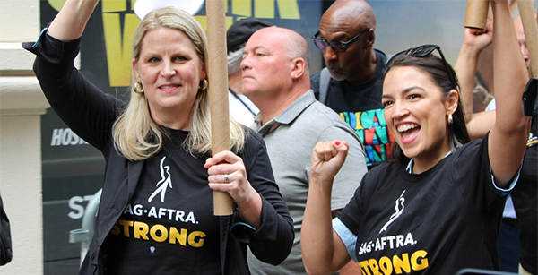 A photo of AFL-CIO President Liz Shuler (left) and Rep. Alexandria Ocasio-Cortez (right) supporting SAG-AFTRA and Writers Guild of America, East (WGAE), members on strike in New York City on Monday.