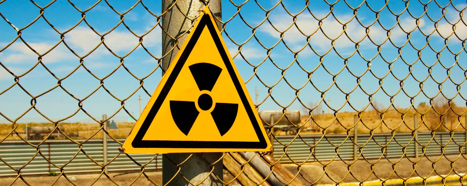 A radioactive hazard sign on the fence of a uranium mine