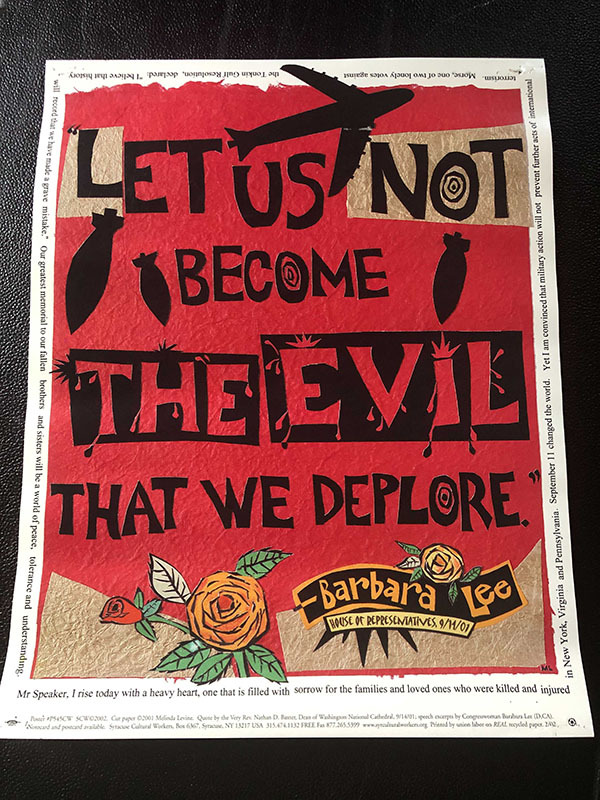 A photo of a poster made from Barbara Lee’s famous 2001 speech from the House floor, which Jason made and hung in his classroom at the time. The poster includes cut out letters spelling out the primary quote: “Let us not become the evil that we deplore.” featuring images of a war plane dropping bombs and a rose blooming at the bottom. The entire speech is written in small text framing the main image.