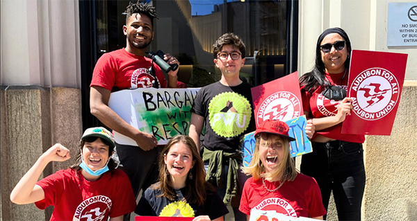 A photo of the workers of the National Audubon Society with their fists raised.