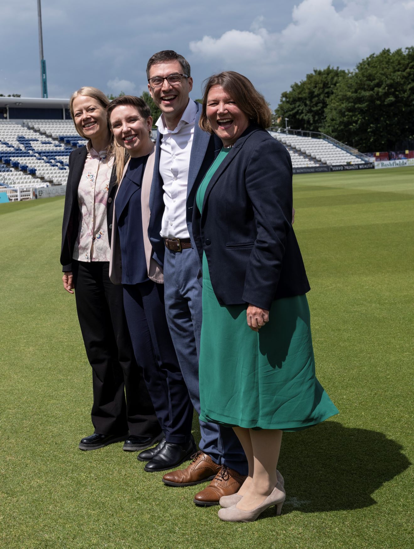 Sian, Carla, Adrian and Ellie standing together and smiling at Sussex Cricket Ground during Green Party manifesto launch.