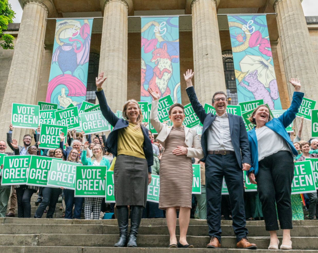 Sian, Carla, Adrian and Ellie waving and smiling during Green Party campaign launch.