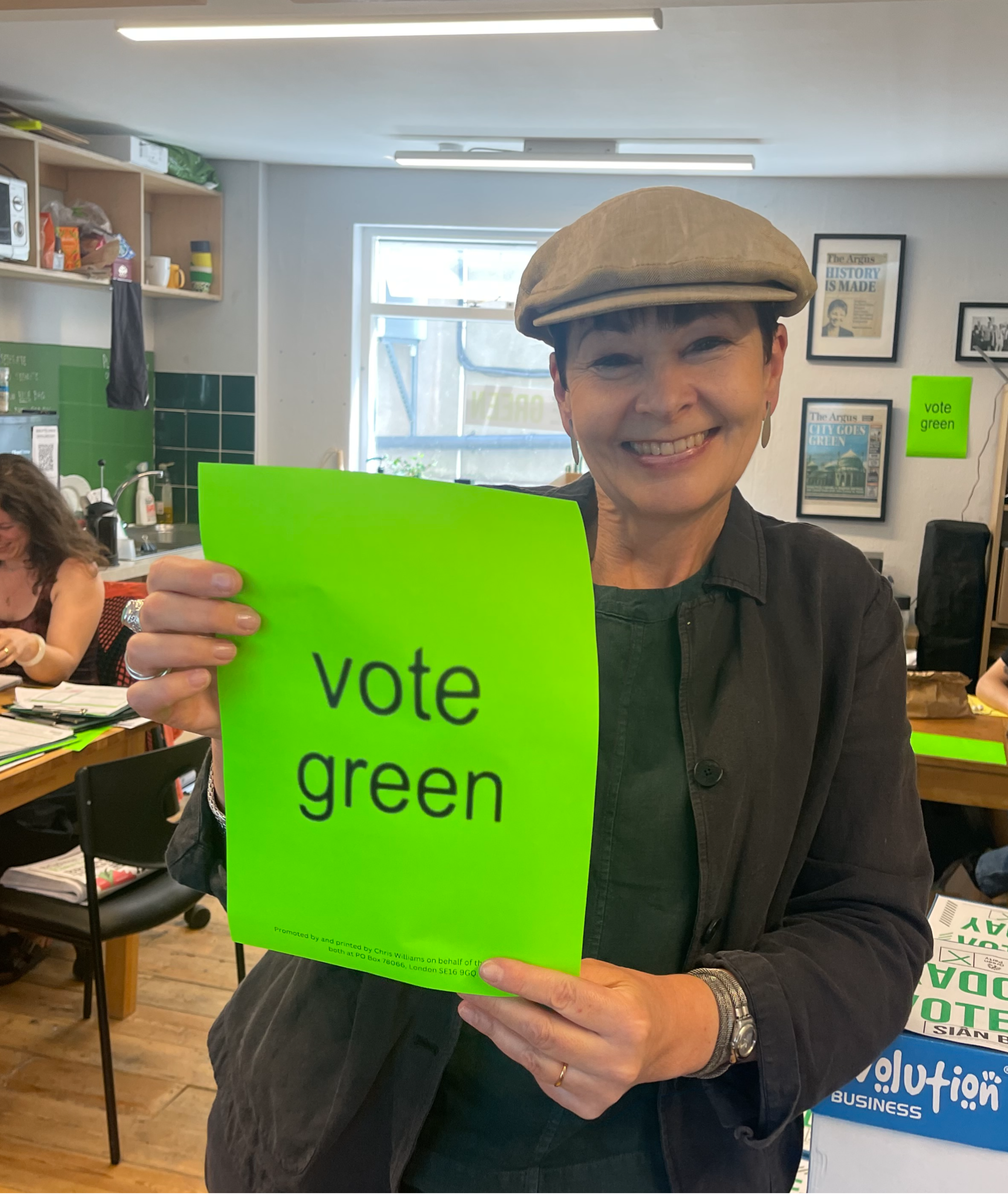 Caroline Lucas holding a Vote Green poster.