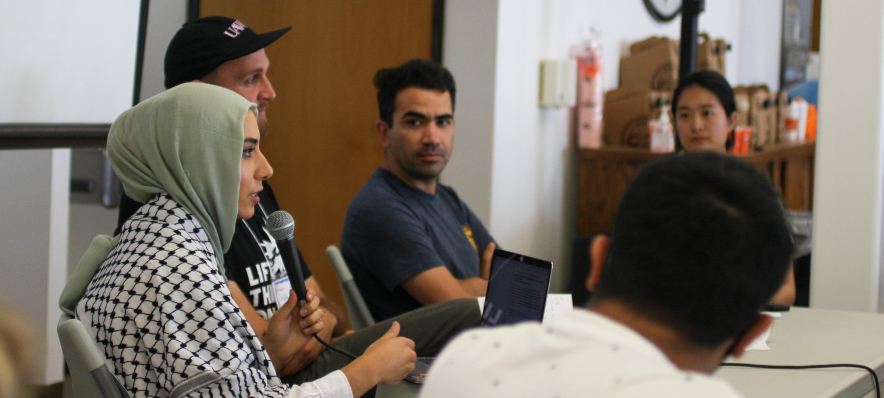 Four people seated at a table for a panel on justice for Palestine