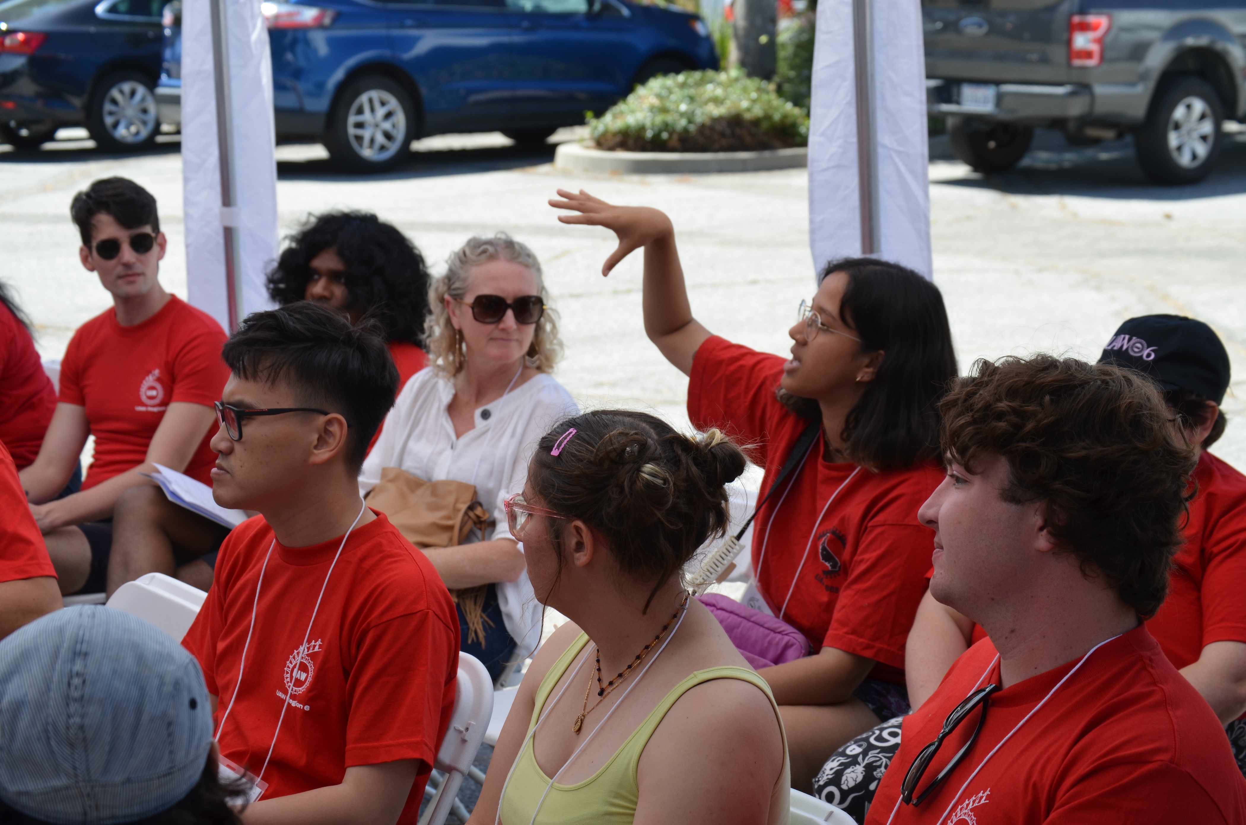 A group of about 8 people sitting in a workshop and listening as one participant speaks