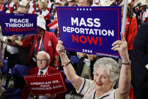 A photo of Republican National Convention attendees holding up signs that read “Mass Deportation Now! 2024