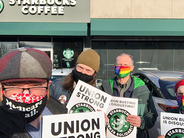 A photo of Jason and several supporters standing outside a Starbucks in WA-02 with signs supporting the Starbucks Worker Solidarity movement.