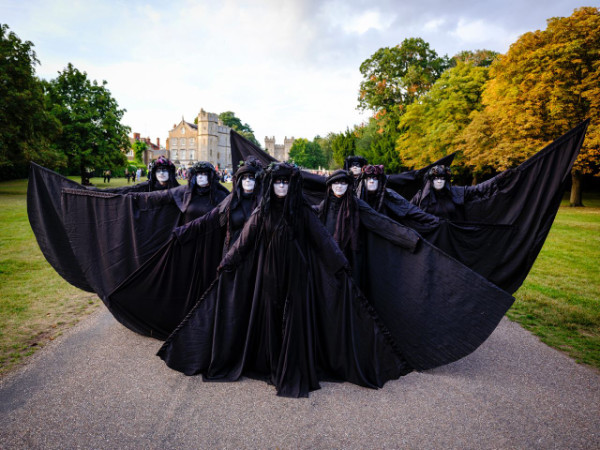 Eight 'oil-slick' black cloaked performers