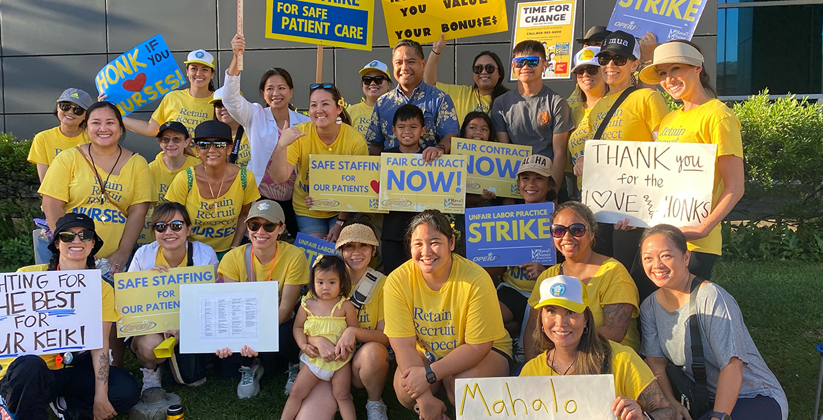 A picture of nurses in yellow shirts holding signs that say, “Fair Contract Now” and “Safe Staffing for Patients,” among others.