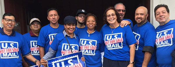 A picture of postal workers in blue shirts that read, “U.S. mail not for sale.”