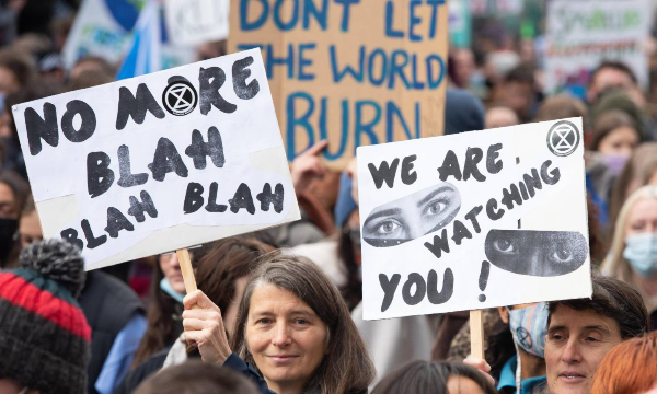 'No more blah blah blah' and 'We are wathcing you!' placards.