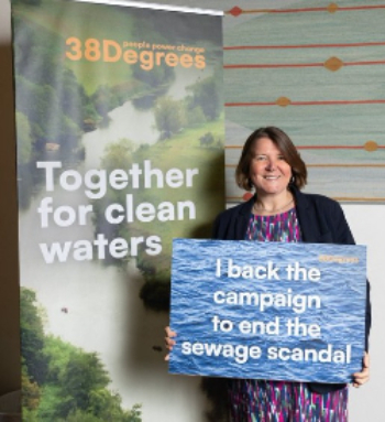 Ellie Chowns MP pictured holding a placard saying 'I back the campaign to end the sewage scandal'.