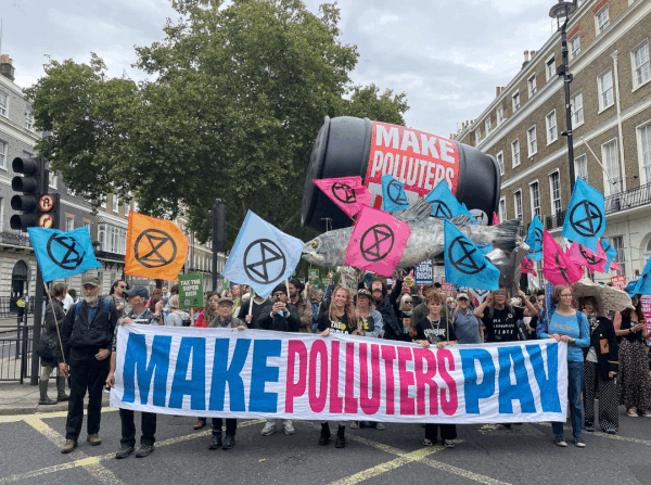 Protestors on the streets with banners at Make Them Pay march