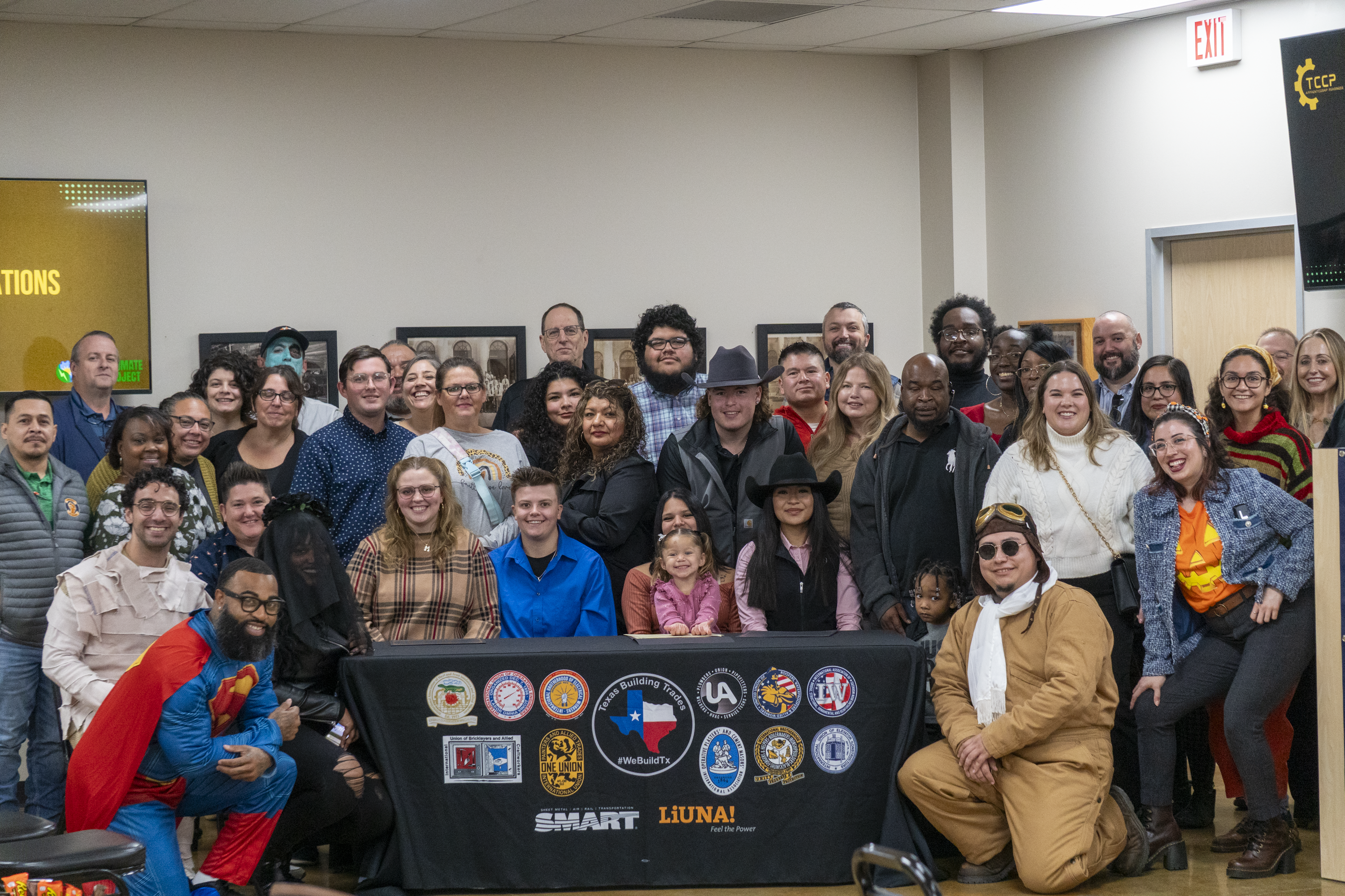 Group photo of graduates, family, and supporters of the TCCP program on Halloween.