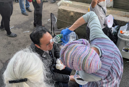 A photo of Senator Andy Kim getting his eyes washed out with water after getting pepper-sprayed.