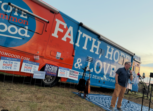 A screenshot of Robb Ryerse speaking in front of the Faith, Hope, & Love Bus.
