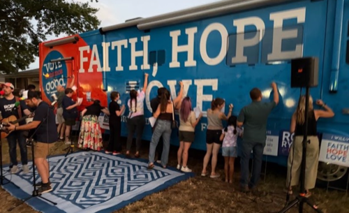 A photo of folks signing the Faith, Hope, & Love bus in honor of the donors who've given to Vote Common Good.