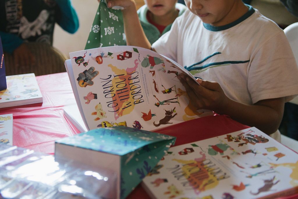 Two children looking at Coloring Without Borders book