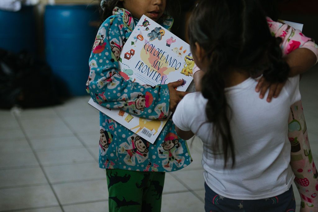Two children with the Coloring Without Borders book