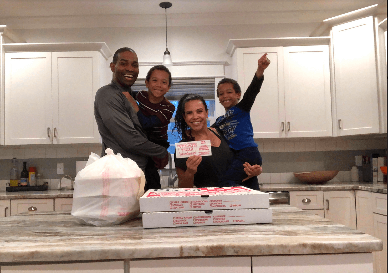 Antonio and family with their takeout from Village Pizza.